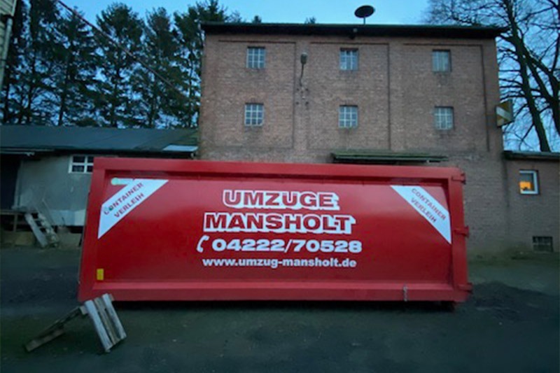 Container von Umzugsunternehmen Umzüge Mansholt vor einem alten Gebäude