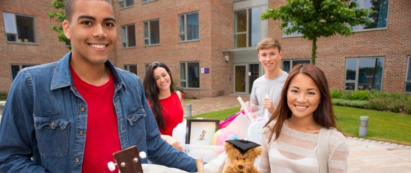 Vier Studierende mit ihrem Gepäck vor dem Umzug ins Studentenwohnheim