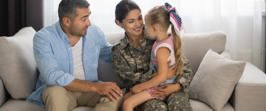 Eine Soldatin mit Mann und Kind sitzt auf einem Sofa