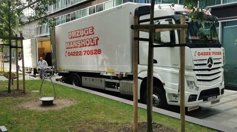 Umzugs-LKW von Umzug Mansholt steht vor einem Büro-Gebäude