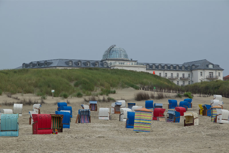 Das Strandhotel Kurhaus in den Dünen hinter einigen Strandkörben