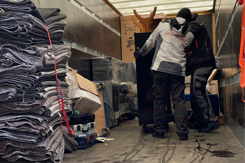 Blick ins Innere eines Umzugswagens mit einem Packer. Etwas freier Platz ist noch vorhanden