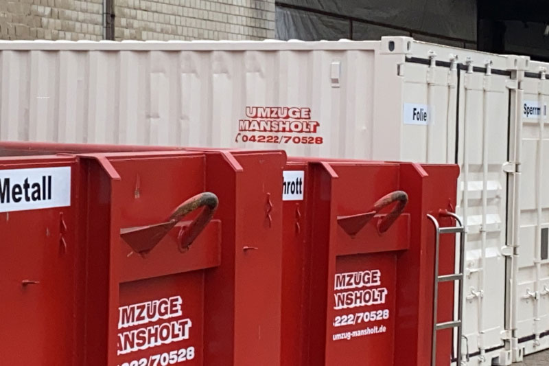 Ein roter Kipp-Computer füllt einen roten Abfallcontainer mit Müll