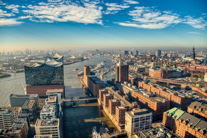 Luftaufnahme des Hamburger Hafens mit Elbphilharmonie, Speicherstadt und Wasserwegen an einem klaren Tag