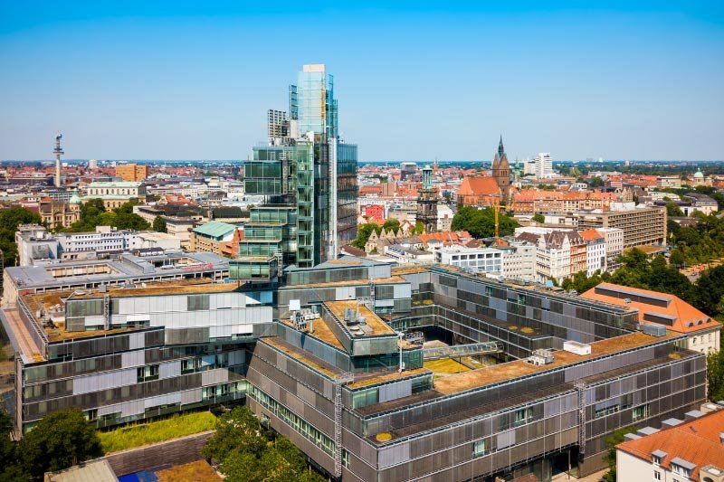 Luftaufnahme eines modernen Bürogebäudes mit Glasfassade im Zentrum von Hannover bei klarem Himmel