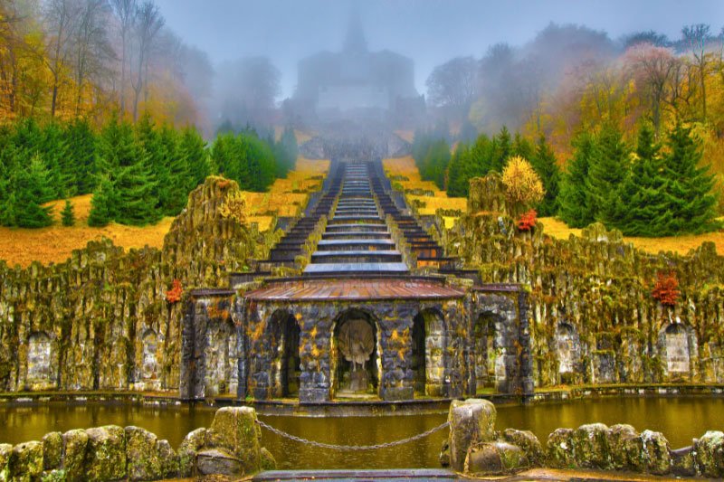 Herkules-Denkmal im Bergpark Wilhelmshöhe in Kassel mit Kaskaden, barocker Architektur und herbstlicher Parklandschaft im Nebel