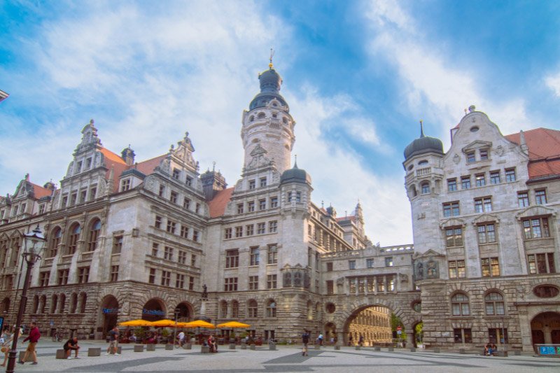 Historisches Rathaus und Marktplatz in Leipzig mit Renaissancefassade, Arkaden und belebter Altstadt unter blauem Himmel