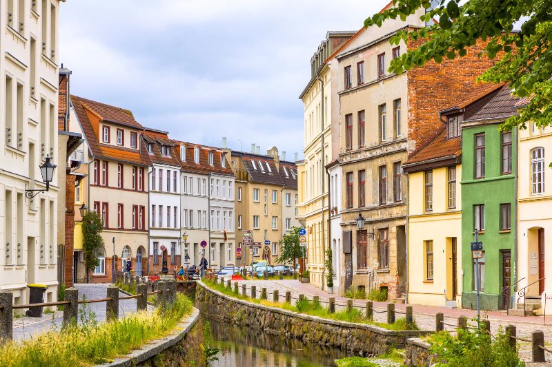 Altstadthäuser entlang eines kleinen Wasserlaufs in Wismarer Altstadt mit liebevoll restaurierten Fassaden und typischer norddeutscher Architektur